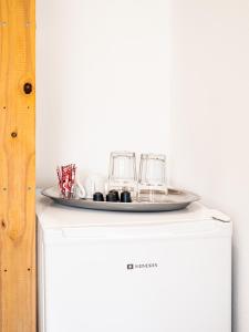 a table with glasses on top of a refrigerator at Bodini's Rooms in Himare