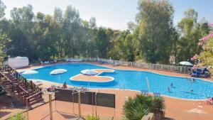 a large swimming pool with umbrellas and people in it at L'Appartamentino in Casa Donato