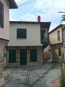 a house with green doors on the side of it at Heidis Haus in Polygryos