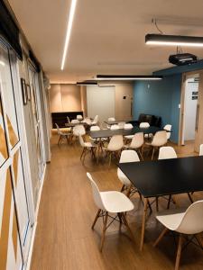 a classroom with tables and chairs in a room at Atlântico Golden Apart Hotel in Santos