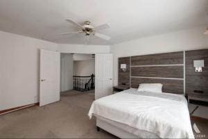 a bedroom with a white bed and a ceiling fan at AEQ Luxury House 1 in Orland Park
