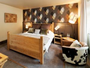 ブリュッセルにあるアスプリア ロイヤル ラ ラサンテ ホテル＆スパのベッドルーム(大型ベッド1台、椅子付)