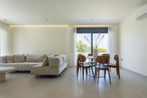 a living room with a couch and a table and chairs at Noera Villas in Kremasti