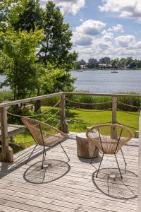 two chairs and a bench on a deck near the water at Lake Glamp Mikołajki - Adults Only in Mikołajki