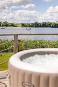 a bath tub next to a body of water with boats at Lake Glamp Mikołajki - Adults Only in Mikołajki +93 photos