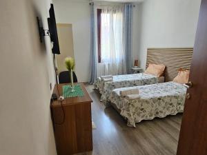 a hotel room with two beds and a table at La dimora di Gabi in Marghera