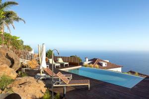 a villa with a swimming pool next to the ocean at Massapez Royals in Fajã da Ovelha