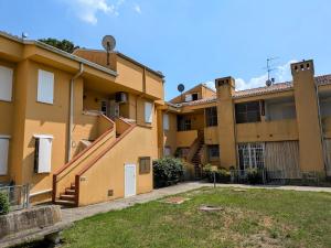 an apartment building with a staircase in a yard at Vear Hausing - Volano 80 int 8 in Lido di Volano