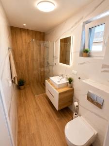 a bathroom with a toilet and a sink and a shower at AMD Apartamenty Ustka *** in Ustka +61 photos