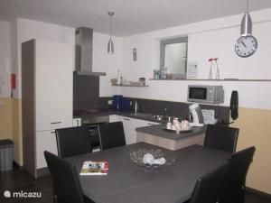 a kitchen with a black table and chairs and a counter at Villa Boskoop in Stryck