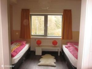 a small bedroom with two beds and a window at Villa Boskoop in Stryck