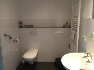 a white bathroom with a toilet and a sink at Villa Boskoop in Stryck +11 photos