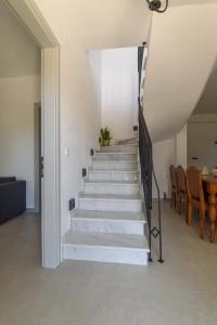 a staircase in a house with chairs and a table at Orange House - Upper West apartment in Promírion