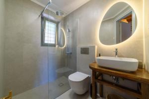 a bathroom with a sink and a toilet and a mirror at Orange House - Upper West apartment in Promírion