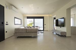 a living room with a couch and a table at Noera Villas in Kremasti