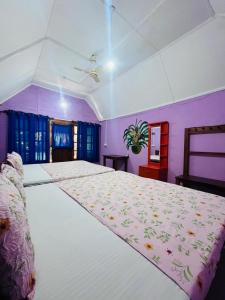 a large bed in a bedroom with purple walls at Vitamin sea beach cabana in Nilaveli +55 photos