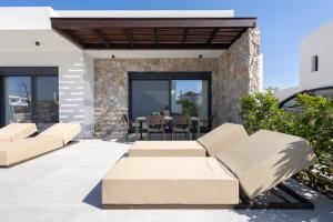 a patio of a house with couches and a table at Noera Villas in Kremasti