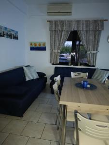 a living room with a table and a couch at Silver SPOT Raches in Kouvéla