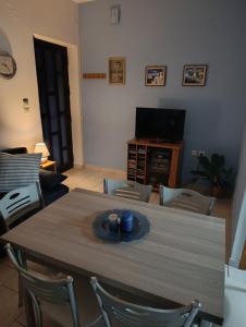 a table and chairs in a living room with a television at Silver SPOT Raches in Kouvéla +17 photos