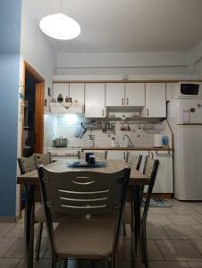 a kitchen with a table and chairs and a refrigerator at Silver SPOT Raches in Kouvéla
