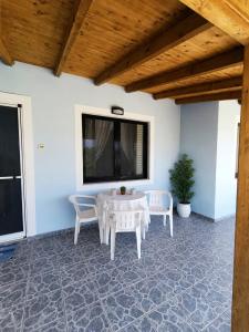 a patio with a table and chairs and a window at Silver SPOT Raches in Kouvéla