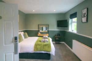 a bedroom with green walls and a bed with a mirror at Bronte Breaks in Haworth
