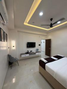 a bedroom with a bed and a flat screen tv at Hotel Krishna Leela Lodging and Boarding in Bhusāwal