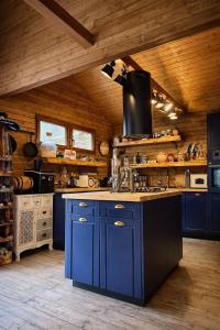 a large kitchen with blue cabinets and a wooden ceiling at Cabana Manea Forest Hub in Topleţ