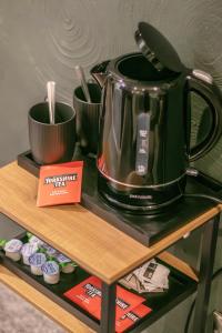 a tea kettle and cups on a shelf at Bronte Breaks in Haworth