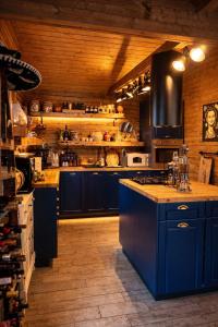 a kitchen with blue cabinets and a blue island at Cabana Manea Forest Hub in Topleţ