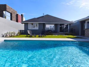a house with a swimming pool in front of a house at Incense in Água de Alto