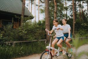 two girls riding a bike on a dirt road at Sosnowy Taras in Koszele