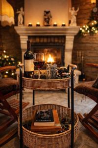 a table with a bottle of wine and a glass at Cabana Manea Forest Hub in Topleţ +6 photos