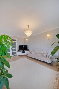 a living room with a white couch and a chandelier at Zumra's White Houses in Trabzon