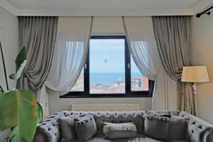 a living room with a couch in front of a window at Zumra's White Houses in Trabzon