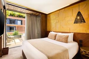a bedroom with a large bed and a balcony at Golden Valley Hotel in Medellín +53 photos