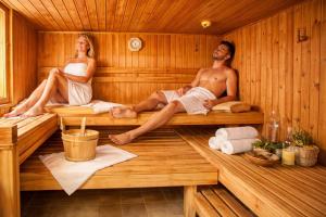 a man and woman sitting in a sauna at Hotel Batzenhäusl in Innsbruck