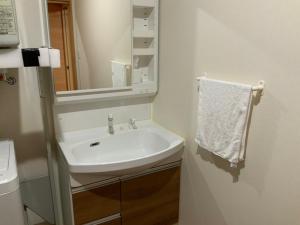 a white bathroom with a sink and a mirror at AZ Hotel - Vacation STAY 56058v in Akaoki +9 photos