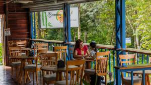 two women sitting at a table in a restaurant at Tabulia Tree Hotel and Villas in Manuel Antonio