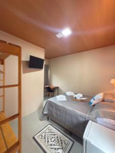 ein kleines Zimmer mit einem Bett und einem Fernseher in der Unterkunft Casa Sol da Ilha in Angra dos Reis