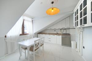 a white kitchen with a white table and chairs at Zumra's White Houses in Trabzon
