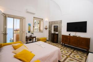 a bedroom with a large bed and a television at Villa Setteventi in Positano