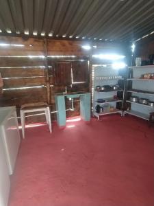 a room with a table and a red carpet at Camping do edmar in São Roque de Minas