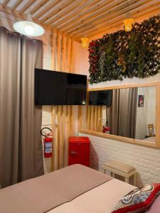 a bedroom with a bed and a flat screen tv at Attardo's House in Catania +3 photos