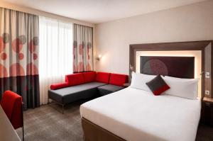a hotel room with a bed and a couch at Rénéa Hotel in Sétif