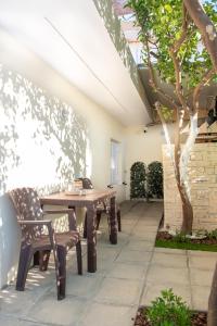 an outdoor patio with a wooden table and chairs at La Casa Seni Near Athens Airport in Papangeláki