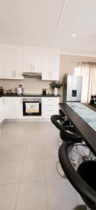 a kitchen with white cabinets and a black counter top at Honey Cove in Mossel Bay