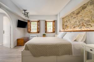 a bedroom with a large bed and a stone wall at Old Town Tower House in Kos