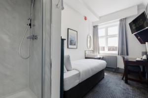 a hotel room with a bed and a shower at Southern Cross in Watford