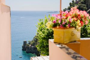 a yellow pot of flowers on a balcony overlooking the ocean at Villa Setteventi in Positano